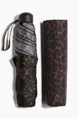Paraguas plegable con estampado de leopardo en tonos marrones y grises. Incluye funda protectora con el mismo estampado y asa superior de plástico negro.