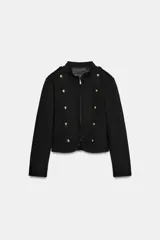 Blazer corto de color negro con cuello mao, manga larga y cierre frontal con cremallera. Presenta doble botonadura decorativa con botones dorados y forro interior a tono.