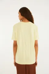 Remera de manga corta color amarillo, de calce relajado, con cuello redondo y estampa frontal alusiva a Río de Janeiro.