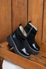 Botas de cuero negras con plataforma y hebilla lateral.