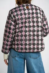 Campera acolchada color verde militar, con cuello redondo y cierre frontal de broches a presión. Presenta un patrón de costuras onduladas.