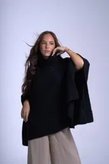 Poncho tejido color beige, con cuello alto y corte asimétrico.