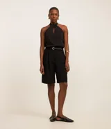 Blusa de chiffon negra sin mangas, con cuello halter y detalle de recorte cutout en el frente.