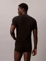 Pack de tres remeras de cuello redondo y manga corta, confeccionadas en una mezcla de algodón, poliéster y elastano. Incluye una remera roja, una blanca y una negra, todas con el logo de Calvin Klein bordado en el bajo.