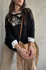 Sweater negro con diseño bordado en hilo crudo en el escote y el hombro, de manga larga y calce holgado.