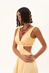 Vestido largo de tela sedosa color durazno, con escote en V, aberturas laterales en la cintura (cut-out) y tajos laterales en la falda. Posee espalda regulable con lazo y elástico.