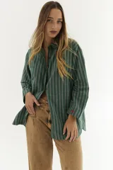 Camisa blanca de algodón con botones marrones, corte holgado y mangas largas.