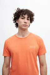 Remera naranja de algodón con estampa en la espalda que incluye texto y el logo de la marca.