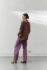 Blusa marrón con estampado animal print en tonos verde y negro, cuello camisero y botones en la parte delantera.