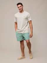 Short de baño azul marino con cintura elástica ajustable con cordón y logo de la marca bordado en rojo en la pierna izquierda.