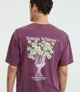 Remera boxy de algodón desteñido color lila, de corte holgado, cuello redondo y manga corta. Cuenta con un pequeño estampado floral en el pecho y un diseño más grande en la espalda.