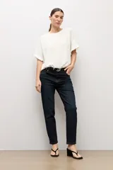 Blusa crudo con textura plumetti, escote redondo y mangas cortas terminadas en delicados volados.