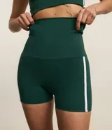 Bermuda deportiva de alta compresión, color verde oscuro, con cintura ancha doblada y detalle de bies lateral en color blanco.