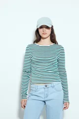 Remera de manga larga con diseño de rayas horizontales en color verde y blanco, de calce ajustado al cuerpo y cuello redondo.