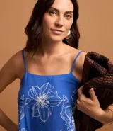 Blusa azul con estampa floral tropical blanca, escote recto y breteles finos ajustables.