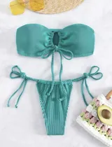 Conjunto de bikini turquesa acanalado, compuesto por un corpiño strapless con lazo central y una bombacha con tiras laterales ajustables.