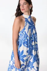Vestido largo de poliéster con estampado floral en tonos azul y blanco, cuello halter y corte holgado.