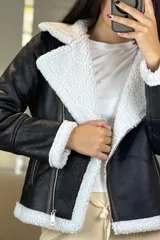Campera tipo gamulán de cuero sintético negro con interior y solapas de corderito blanco. Presenta cierre frontal cruzado y bolsillos laterales con cierre.