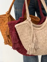 Cartera tipo shopper de gamuza trenzada, con tiras trenzadas para el hombro y detalle de borlas colgantes.