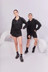 Buzo negro de rústico de algodón, con cierre frontal y reguladores en la parte inferior.