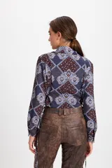 Camisa corta estilo corset de color blanco, con cuello clásico, cierre frontal de botones y detalles de cordones laterales ajustables. Presenta pinzas frontales y traseras para un ajuste entallado.