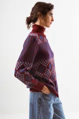 Sweater de cuello alto con diseño de tejido jacquard en tonos marrones y negros, con patrón geométrico y de rayas verticales, de manga larga con puños acanalados.