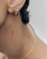 Par de caravanas colgantes de plata de ley con baño de oro de 18k, con piedra natural de ojo de tigre redonda de la que cuelga una fina cadena con barra decorativa.