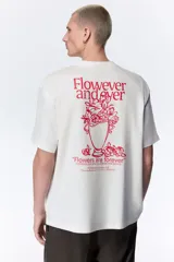 Remera de algodón blanca de corte holgado, con cuello redondo y diseño estampado en el pecho con texto en color rojo.