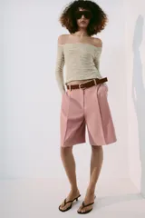 Top de punto texturizado color beige, con escote barco y manga larga.