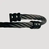 Pulsera rígida de acero trenzado color gris oscuro con terminales cilíndricos negros.