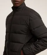 Campera puffer Marfinno de microfibra color marrón, con cuello alto, cierre frontal de cremallera y diseño acolchado horizontal.