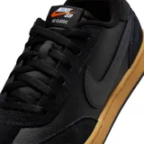 Championes Nike SB FC Classic, color negro con suela de goma color caramelo. Presentan una combinación de cuero texturizado y gamuza en la parte superior, con el icónico logo de Nike en el lateral.