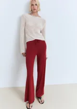 Pantalón de punto fino color bordó, de diseño recto y largo, con cintura elástica y cordón ajustable.