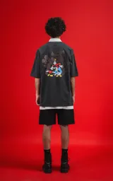 Remera de algodón premium color gris melange oscuro, con corte oversize y estampa pequeña de Mickey Mouse en el pecho.