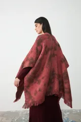 Ruana de tejido de punto con diseño teñido artesanalmente en tonos coral y marrón, con terminación de flecos en el ruedo.