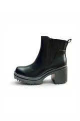 Bota corta tipo chelsea color negro, con elástico lateral estriado, plataforma dentada y taco ancho.