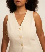 Chaleco color crudo confeccionado en viscolino, con escote en V, botones color carey y bolsillos delanteros.