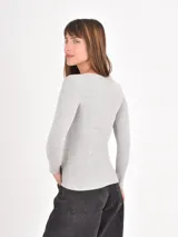 Remera de manga larga con diseño de rayas horizontales finas en blanco y negro, cuello redondo y corte ajustado.