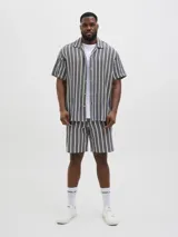 Camisa de manga corta con cuello resort y fit regular. Tejido plano de sarga con textura suave y caída ligera. Cierre frontal con botones.