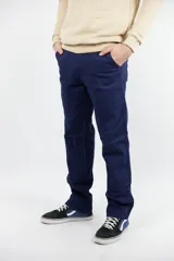 Pantalón jean azul marino, de corte recto, con bolsillos laterales y traseros. Se ajusta a la cintura con cinturón de cuero marrón.