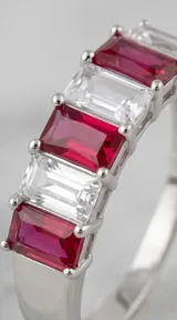 Anillo de plata con diseño de banda compuesto por cristales rectangulares en corte baguette, alternando tonos fucsia y blanco.