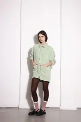 Sobrecamisa verde agua de pana con cuello camisero, cierre frontal con botones y bolsillos de parche.