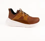 Championes de diseño artesanal en tonos tierra, combinando cuero liso, cuero con textura de reptil y gamuza. Presenta suela blanca de plataforma, cordones al tono y detalles perforados en la puntera.