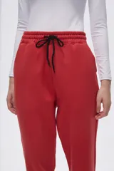 Pantalón tipo babucha de corte recto, confeccionado en tejido con felpa, con cintura elástica y cordón de ajuste frontal.