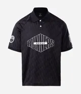 Polo de manga corta con cuello camisero y cierre frontal de botones. Presenta un diseño boxy fit con estampado gráfico en el pecho y detalle en la manga. Confeccionada en tejido técnico de microfibra.