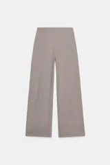 Pantalón de tiro alto con pierna ancha, confeccionado en sarga color tostado. Presenta detalle de doble hilera de botones metálicos dorados en el frente y pinzas verticales.