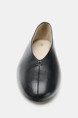 Zapato tipo bailarina de piel color negro, con escote en V y punta redonda.