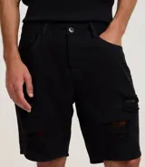 Bermuda masculina de sarga color beige con corte slim, diseño con roturas estilo destroyed y cierre tradicional de botón y cremallera.