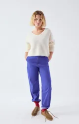 Sweater de punto fino en color beige, con escote en V, mangas largas y corte holgado.