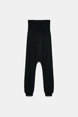 Pantalón baggy de tiro bajo confeccionado en viscosa, con cintura drapeada y puños elásticos en los tobillos.